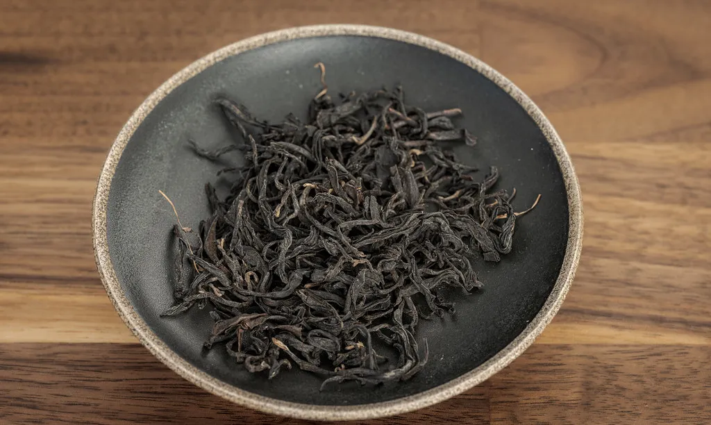 Dark twisted black tea leaves in a ceramic dish